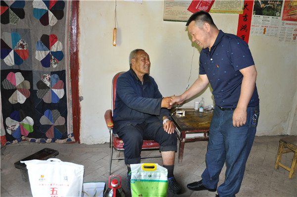 1592559471236507.jpg 与低保户亲切握手交谈.JPG